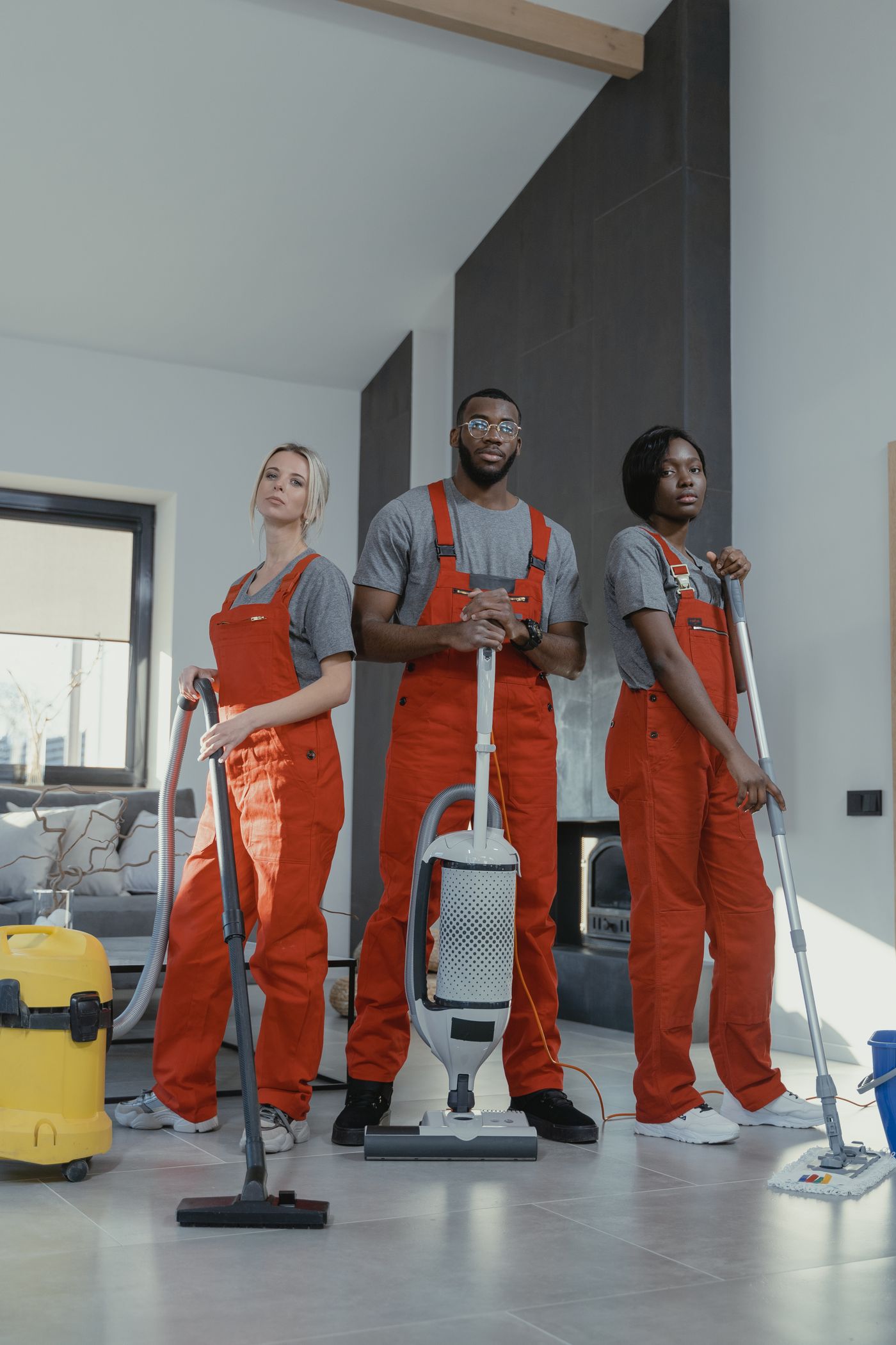Professional cleaning team in uniform with equipment in a modern home