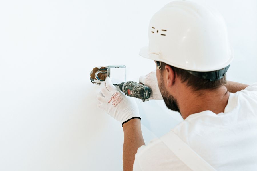 Worker using a power tool to repair a wall