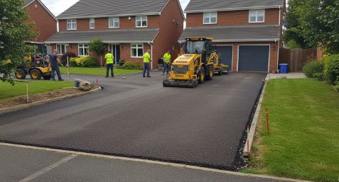 Completed local paving project — fresh driveway with crew on site